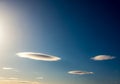 A clear blue sky features several lenticular clouds (Altocumulus Royalty Free Stock Photo