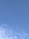Clear Blue Sky with Moon and Wispy Clouds Royalty Free Stock Photo