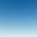 A clear blue sky with a smooth gradient transitioning from a lighter blue at the bottom Royalty Free Stock Photo