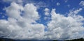 Clear blue sky with soft white clouds