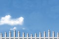 Clear Blue Sky With White Fluffy Clouds And Picket Fence