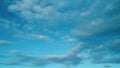 Clear blue sky with white wispy smoke cumulus and cirrocumulus on different layers clouds. Blue sky background with tiny
