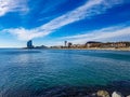 Clear blue water no clouds sky rock stone in ocean sea beach with palm promenade w hotel Barcelona spain holiday tourist