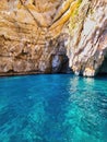 Clear blue water. Rocky coast of the region sea. Sea cave with blue water at daytime. Blue waves crashing against the rocks of the