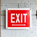 Red Exit Sign with Directional Arrows on a Concrete Wall Royalty Free Stock Photo