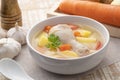 Clear chicken soup with potatoes carrot and onion in white bowl.Asian style food