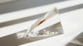 A clear crystal object is sitting on a white surface