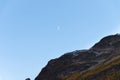 Clear daytime blue sky, mountains and waning white moon Royalty Free Stock Photo