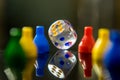 A clear dice and tokens in a reflective surface Royalty Free Stock Photo