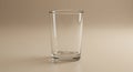 A clear, empty glass placed on a light beige surface. The glass has a cylindrical shape Royalty Free Stock Photo