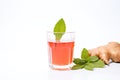 clear glass of beet kvass on white backdrop with fresh beets beside it