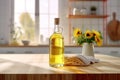 Clear glass bottle with golden sunflower or olive oil on a table with a blurred kitchen background and a vase of