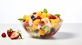 clear glass bowl of fresh fruit salad with strawberries, kiwis, blueberries, raspberries, and mint leaves on a white background Royalty Free Stock Photo