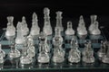 Clear glass chess pieces on a glass chessboard isolated Royalty Free Stock Photo