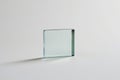 Clear glass cube object with subtle green tint on a neutral white background with soft shadow cast Royalty Free Stock Photo