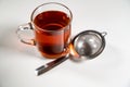 Clear glass cup of hot ceylon black tea in a mug & tea strainer Royalty Free Stock Photo