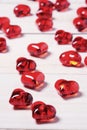 Clear glass effect plastic hearts on a white wooden table. Royalty Free Stock Photo