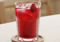 A clear glass filled with a red raspberry beverage, including ice Royalty Free Stock Photo