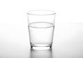 A clear glass halffilled with water on a table surface Royalty Free Stock Photo
