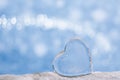Clear glass heart on white glitter and blue background Royalty Free Stock Photo