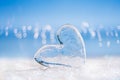 Clear glass heart on white glitter and blue background Royalty Free Stock Photo