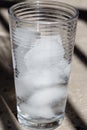 Glass of ice melting, light background Royalty Free Stock Photo