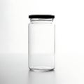 A clear glass jar with a black lid placed on a flat surface Royalty Free Stock Photo