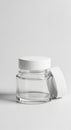 Clear glass jar with a cylindrical shape and a wide, flat base. It features a white, flat lid Royalty Free Stock Photo