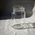 Clear glass jar placed on a light fabric surface casting a soft shadow Royalty Free Stock Photo
