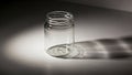 A clear glass jar sits on a flat surface casting a distinct shadow Royalty Free Stock Photo