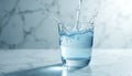 Clear glass of liquid with dynamic splash moment on marble. Water flows into cup. Concept for hydration refreshment purity and Royalty Free Stock Photo