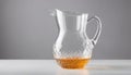A clear glass pitcher with a handle and a yellow liquid in it Royalty Free Stock Photo