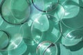 Clear glass round magnifying lenses on turquoise color paper , with light reflections and shadows, abstract texture backdrop Royalty Free Stock Photo