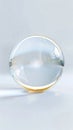 A clear glass sphere with golden rim on a white surface studio shot Royalty Free Stock Photo