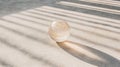 A clear glass sphere rests on a concrete floor, casting a long shadow. Royalty Free Stock Photo