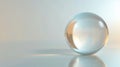 A clear glass sphere sitting on a reflective surface in soft light Royalty Free Stock Photo