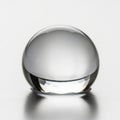 Clear glass sphere with a smooth surface is displayed against a plain Royalty Free Stock Photo