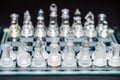 Glass, transparent chess pieces on a checkerboard, selective focus, close-up, isolated on black Royalty Free Stock Photo