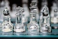 Glass, transparent chess pieces on a checkerboard, selective focus, close-up, isolated on black Royalty Free Stock Photo