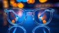 Clear glasses with blue lights in background on reflective surface Royalty Free Stock Photo