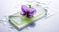 Clear green color natural herbal soap with beautiful violet flower on a wet shiny white surface, close-up, selective focus