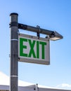 Green Exit Sign Against a Clear Blue Sky (1 Royalty Free Stock Photo