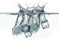 Clear ice cubes splash into water, creating dynamic waves and bubbles Royalty Free Stock Photo