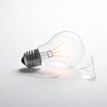Clear Incandescent Light Bulb with Broken Glass Shards on a White Surface shattered Royalty Free Stock Photo