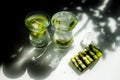 Clear lemonade with ice and kiwi slices. Two glasses stand on the table, the sun`s rays falling on them Royalty Free Stock Photo