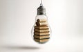 A clear light bulb on a white background with a stack of books and rolled paper scrolls inside it, symbolizing education, learning Royalty Free Stock Photo