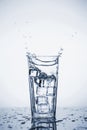Clear mineral water splashes in a glass with ice Royalty Free Stock Photo