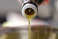 Clear olive oil is poured from dispenser bottle into saucepan closeup Royalty Free Stock Photo