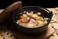 Clear oxtail soup on leaf background, black background.