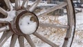 Clear Panorama Close up of the wooden wheel of an old wagon against a snowy terrain in winter Royalty Free Stock Photo